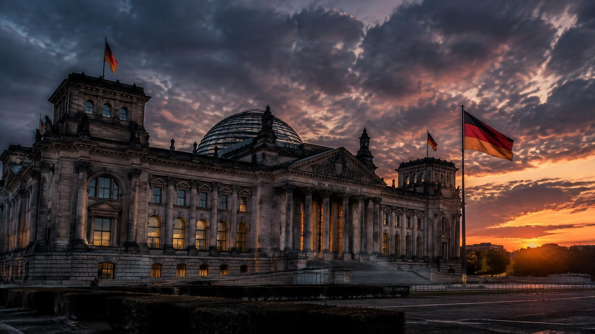 Reichstag building in Berlin with the German flag at dusk